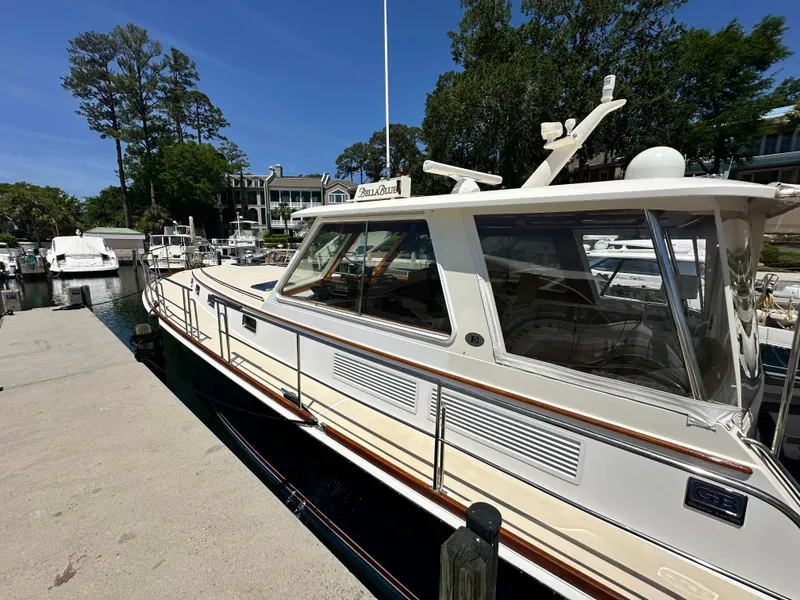 Slide: The Image of 2004 Grand Banks 49 Eastbay HX docked at a marina under clear blue skies. - 12