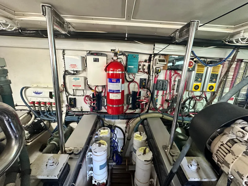 Slide: The Image of Engine room of 2004 Grand Banks 49 Eastbay HX with fire extinguisher and control panels. - 135
