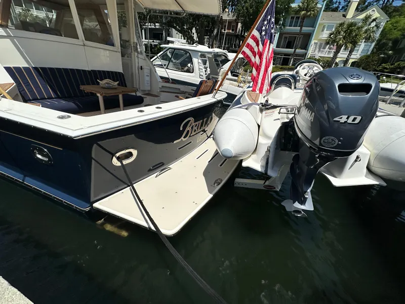 Slide: The Image of 2004 Grand Banks 49 Eastbay HX docked with American flag and Yamaha outboard motor. - 15
