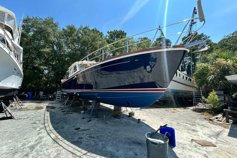 Slide: The Image of 2004 Grand Banks 49 Eastbay HX yacht on dry dock, surrounded by trees and equipment. - 18