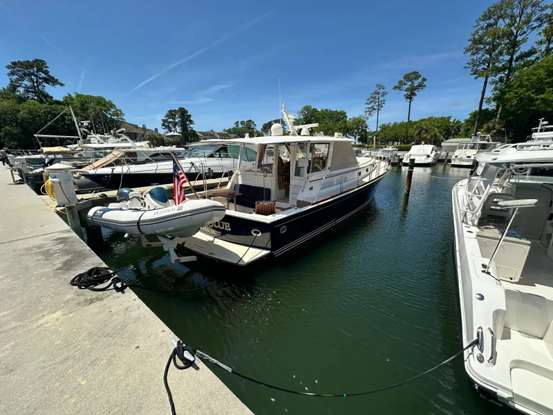 Slide: The Image of 2004 Grand Banks 49 Eastbay HX yacht docked in a marina under clear blue skies. - 3