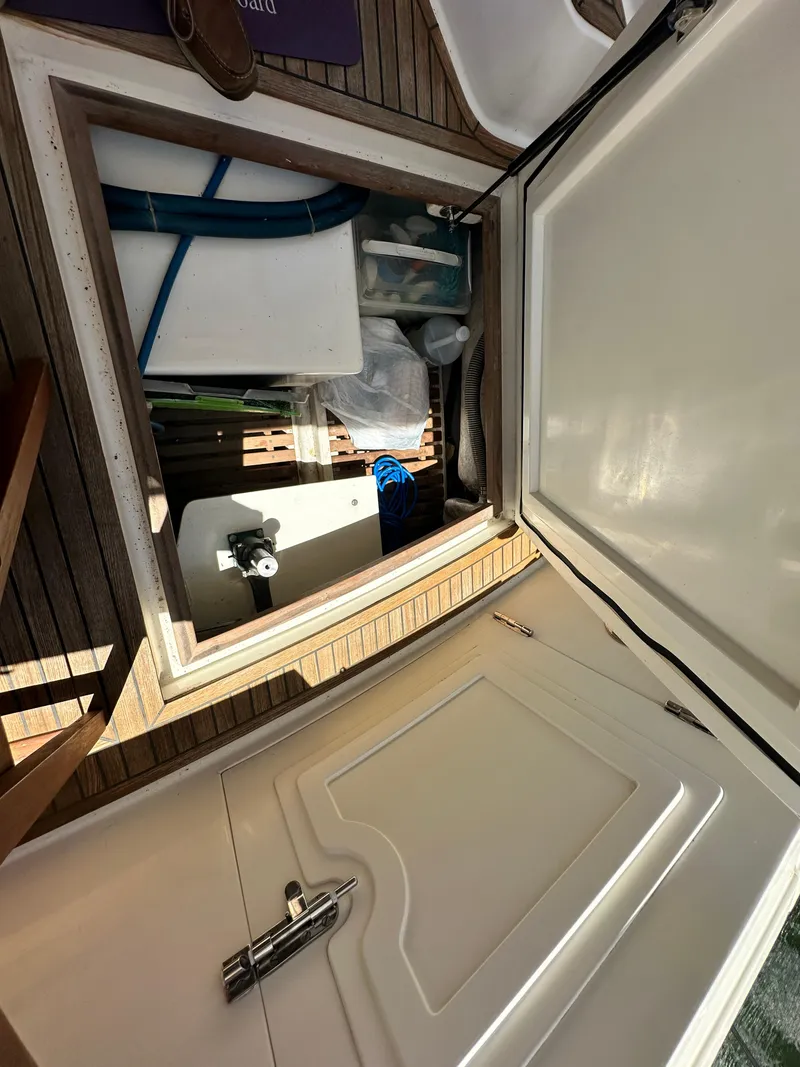 Slide: The Image of Storage compartment on 2004 Grand Banks 49 Eastbay HX yacht, open with various items inside. - 30