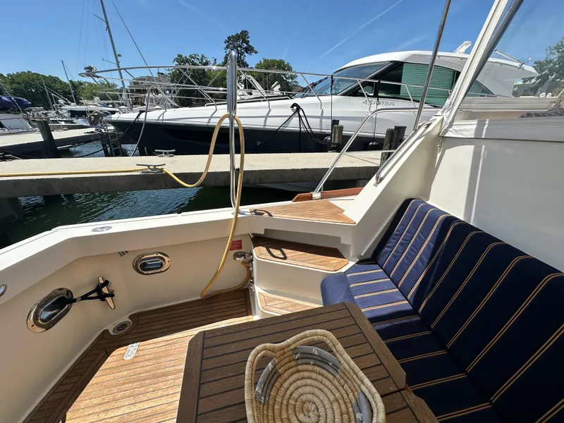 Slide: The Image of 2004 Grand Banks 49 Eastbay HX yacht interior with seating and wooden deck. - 32