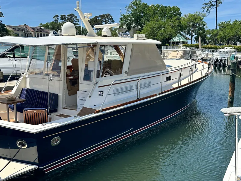 Slide: The Image of 2004 Grand Banks 49 Eastbay HX yacht docked in a marina, featuring a sleek design. - 4