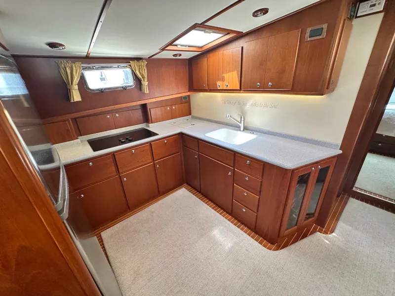 Slide: The Image of Luxurious 2004 Grand Banks 49 Eastbay HX yacht kitchen with wood cabinetry and modern appliances. - 44