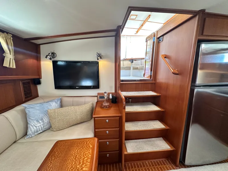 Slide: The Image of Luxurious 2004 Grand Banks 49 Eastbay HX interior with cozy seating, TV, and elegant wood finishes. - 45