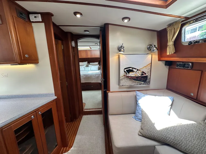 Slide: The Image of Interior of 2004 Grand Banks 49 Eastbay HX yacht, featuring cozy seating and elegant wood finishes. - 49
