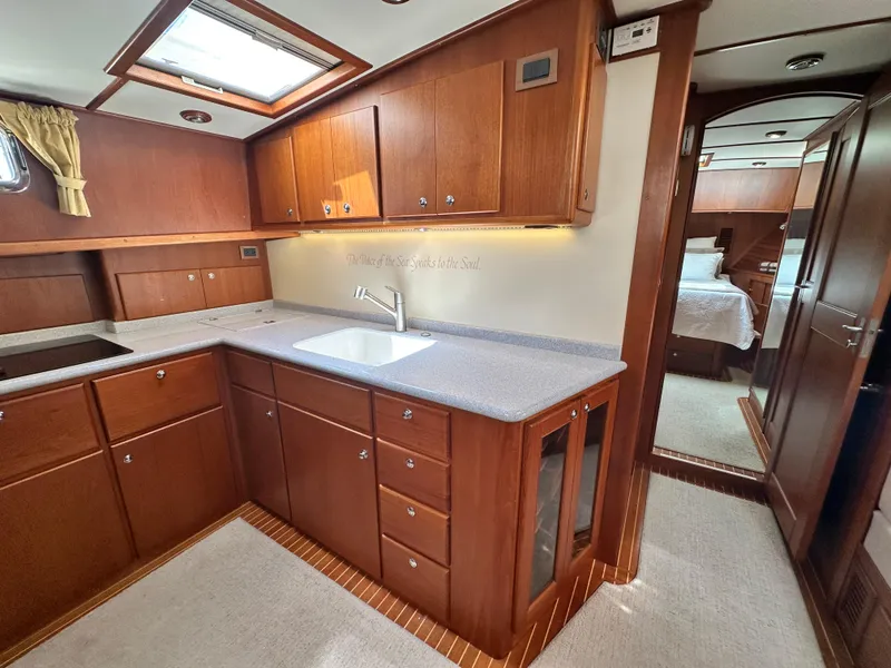 Slide: The Image of 2004 Grand Banks 49 Eastbay HX yacht kitchen with wood cabinetry and modern amenities. - 50