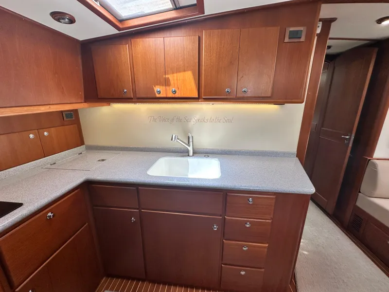 Slide: The Image of 2004 Grand Banks 49 Eastbay HX yacht kitchen with wooden cabinets and modern sink. - 51