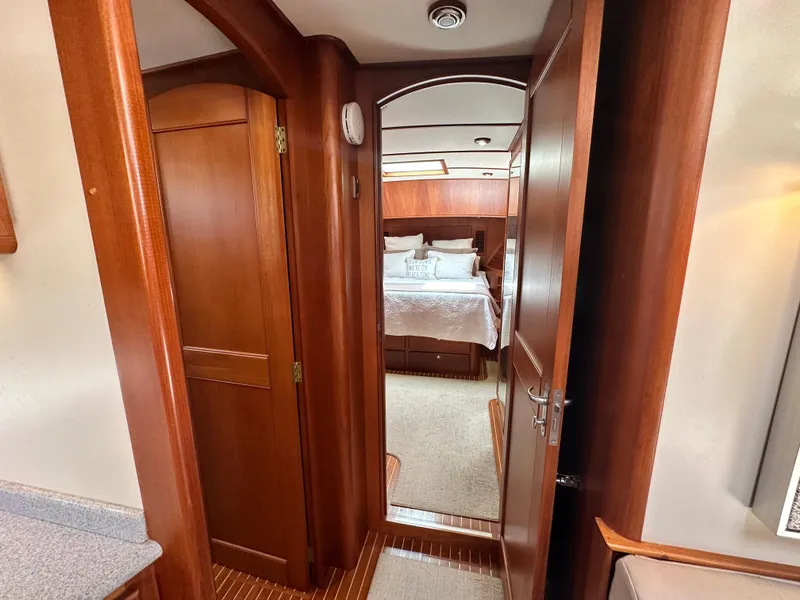 Slide: The Image of Interior of 2004 Grand Banks 49 Eastbay HX yacht, featuring wood paneling and a cozy bedroom. - 55