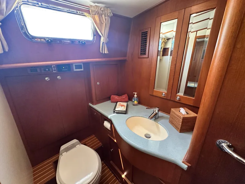 Slide: The Image of Luxurious 2004 Grand Banks 49 Eastbay HX yacht bathroom with wood accents and modern fixtures. - 57