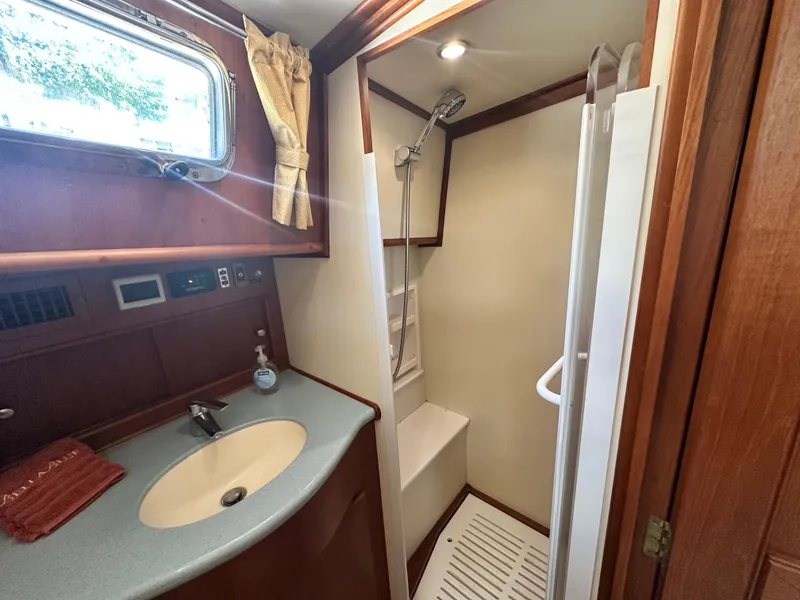 Slide: The Image of 2004 Grand Banks 49 Eastbay HX yacht bathroom with sink, shower, and wooden accents. - 65
