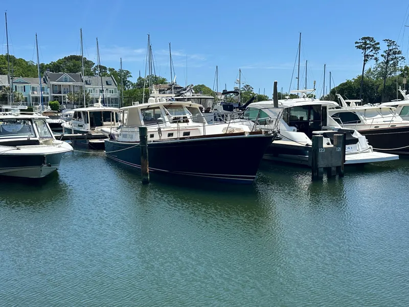 Slide: The Image of 2004 Grand Banks 49 Eastbay HX yacht docked in a marina, surrounded by other boats. - 8