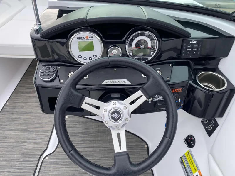 Slide: The Image of 2022 Four Winns HD2 Surf boat dashboard with steering wheel and gauges. - 10