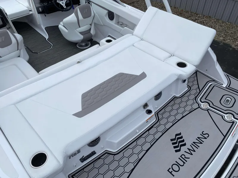 Slide: The Image of 2022 Four Winns HD2 Surf boat interior with white seating and branded flooring. - 5