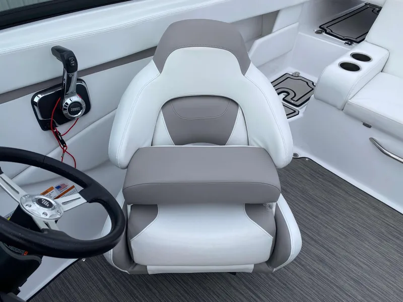 Slide: The Image of 2022 Four Winns HD2 Surf boat interior with steering wheel and cushioned seat. - 9