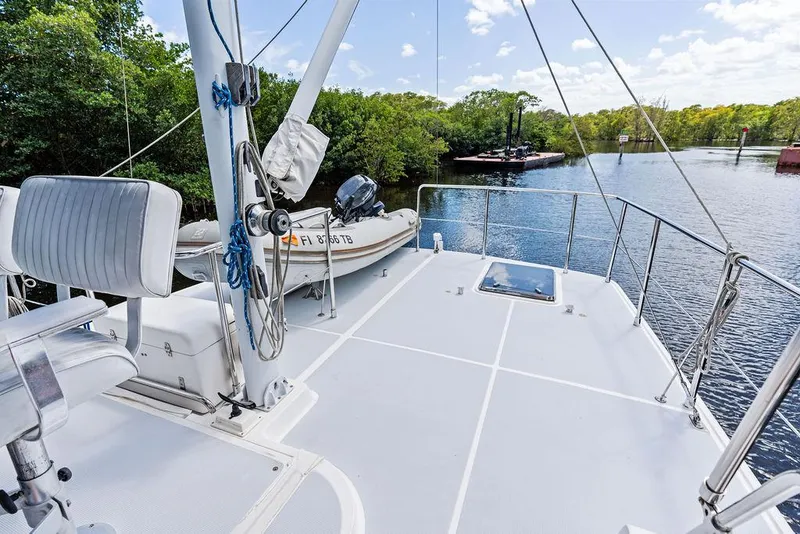 Slide: The Image of Deck of a 2000 Selene Solo yacht on a serene river with lush greenery. - 11