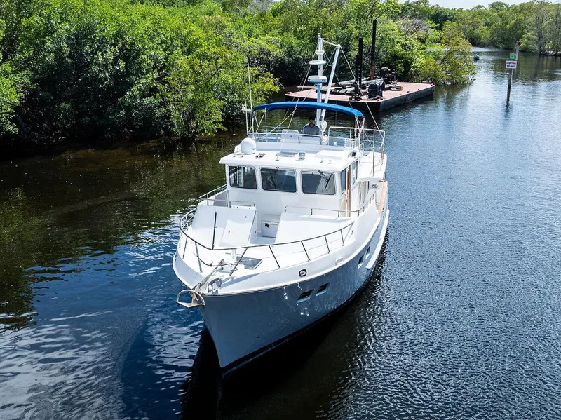 Slide: The Image of Selene Solo 2000 yacht cruising on a serene river surrounded by lush greenery. - 2