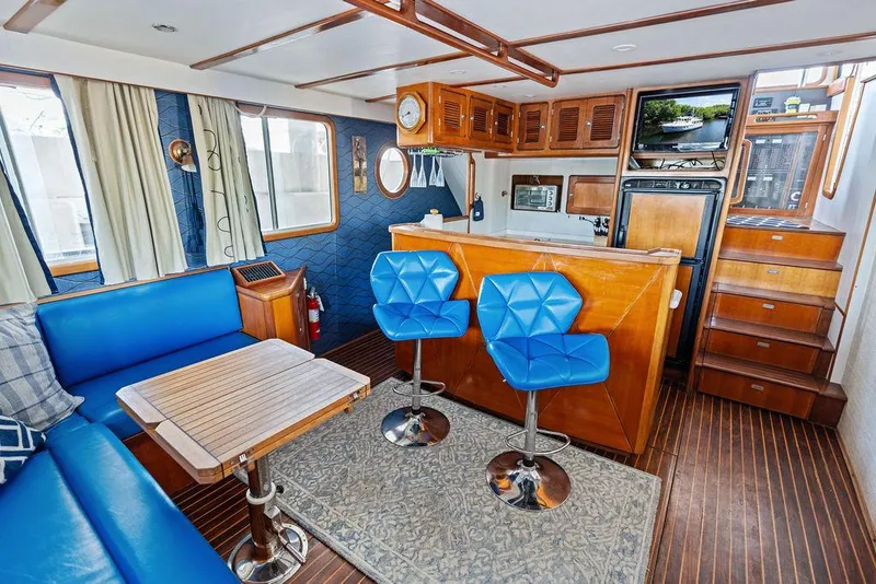 Slide: The Image of Luxurious Selene Solo 2000 yacht interior with blue seating, wooden accents, and modern kitchen area. - 20