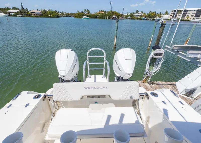 Slide: The Image of 2024 World Cat 260CC boat with dual engines docked by a scenic waterfront. - 15