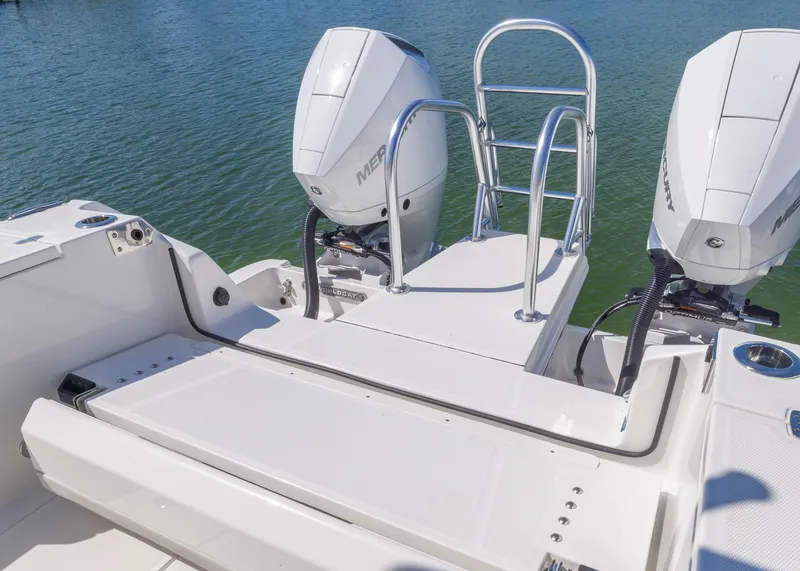 Slide: The Image of 2024 World Cat 260CC boat with dual Mercury engines and swim ladder on calm water. - 19