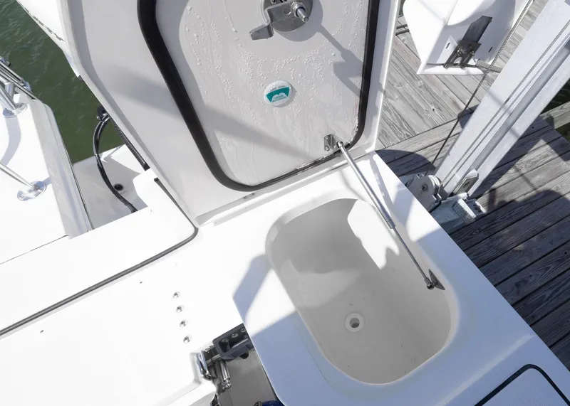 Slide: The Image of 2024 World Cat 260CC boat storage compartment with open hatch, dockside view. - 29