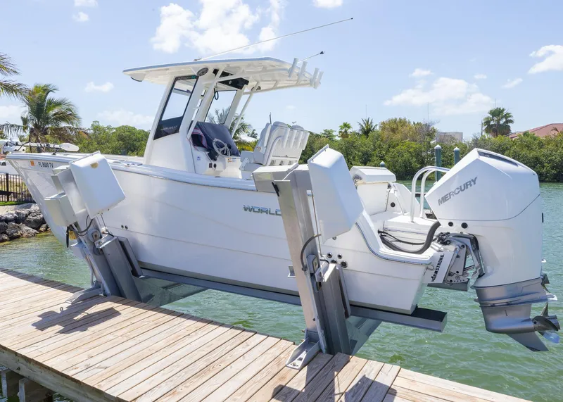 Slide: The Image of 2024 World Cat 260CC boat docked, featuring dual Mercury engines, under a clear blue sky. - 3