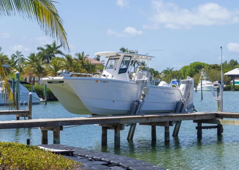 Slide: The Image of 2024 World Cat 260CC boat docked in a tropical marina setting. - 4