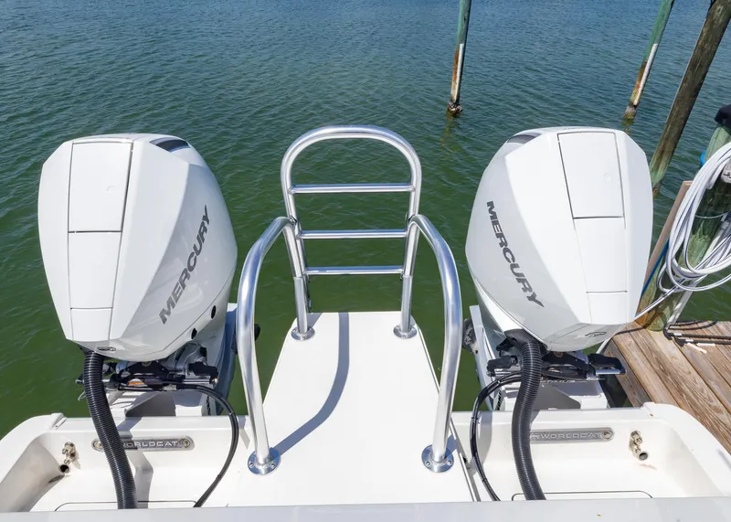 Slide: The Image of 2024 World Cat 260CC boat with dual Mercury engines, docked on calm water. - 5