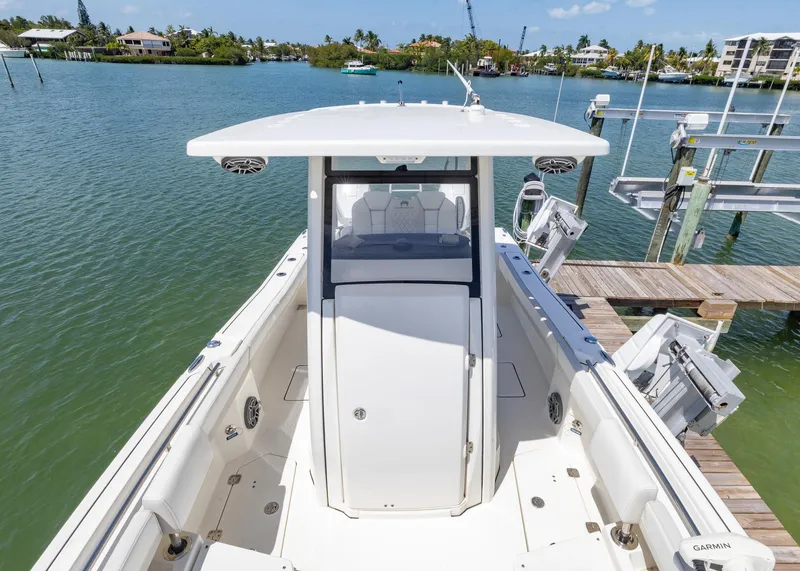 Slide: The Image of 2024 World Cat 260CC boat docked in a scenic marina setting. - 7