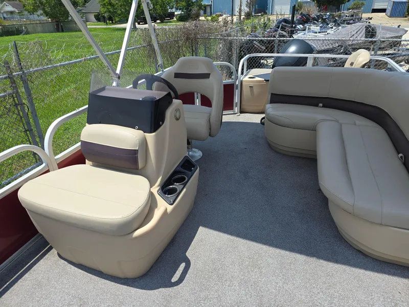 Slide: The Image of 2019 Sun Tracker Bass Buggy 18 DLX pontoon boat interior with beige seating and steering console. - 7