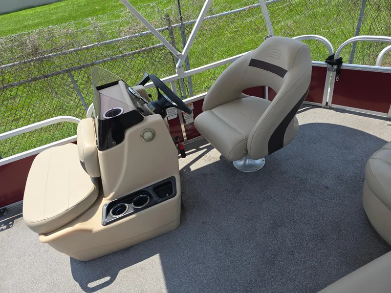 Slide: The Image of 2019 Sun Tracker Bass Buggy 18 DLX interior with helm and seating, featuring beige upholstery. - 9