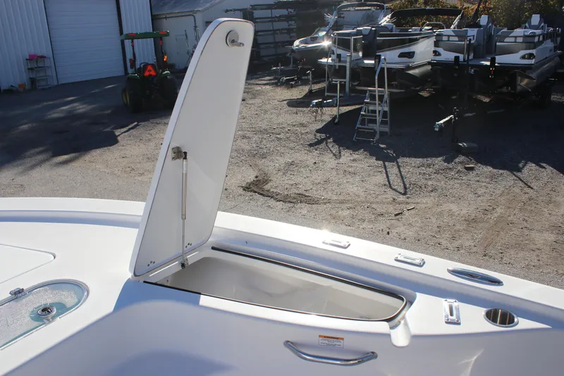 Slide: The Image of 2025 Sea Pro 250 Bay boat with open storage compartment in a marina setting. - 13