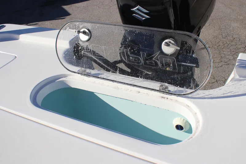 Slide: The Image of 2025 Sea Pro 250 Bay boat with open storage compartment and Suzuki engine. - 6