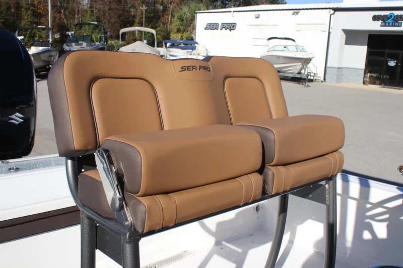 Slide: The Image of 2025 Sea Pro 250 Bay boat seats with brown upholstery, outdoor setting. - 8