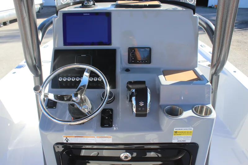 Slide: The Image of 2025 Sea Pro 250 Bay boat console with steering wheel, controls, and navigation screens. - 9