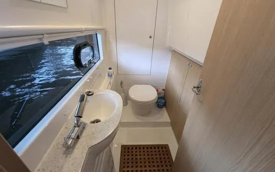 Slide: The Image of Bathroom interior of 2020 Aquila 36 Sport yacht, featuring sink, toilet, and window. - 17