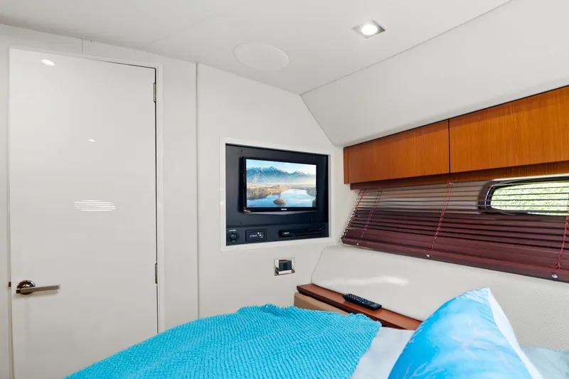 Slide: The Image of Interior cabin of 2013 Sea Ray 410 Sundancer with TV and cozy bedding. - 22