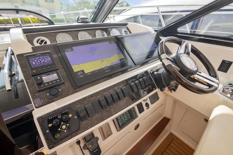 Slide: The Image of 2013 Sea Ray 410 Sundancer helm with advanced navigation and control systems. - 32
