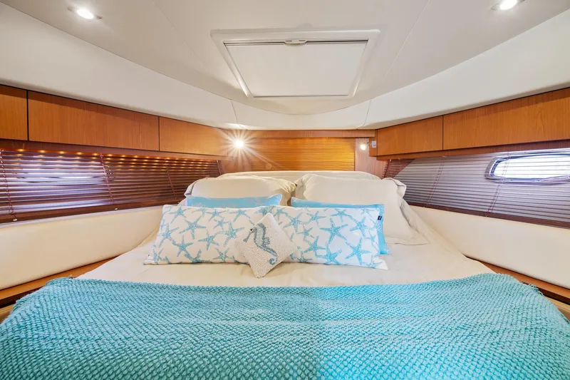 Slide: The Image of Luxurious cabin interior of 2013 Sea Ray 410 Sundancer with cozy bedding and elegant wood finish. - 38
