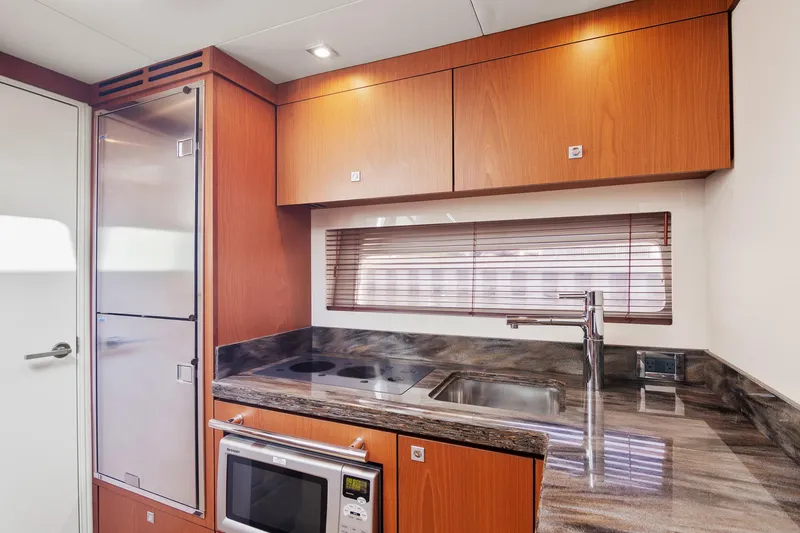 Slide: The Image of Modern kitchen interior of 2013 Sea Ray 410 Sundancer yacht with wood cabinets and stainless appliances. - 42