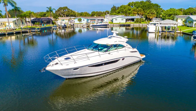 Slide: The Image of 2013 Sea Ray 410 Sundancer yacht docked in a serene marina setting. - 6