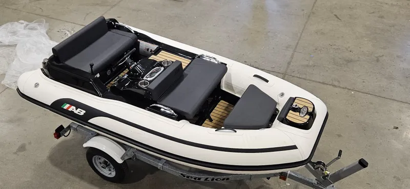 The Image of 2025 AB Inflatables 330 Jet Boat on trailer in a garage setting. - 0