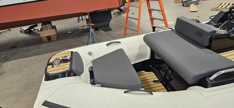 Slide: The Image of 2025 AB Inflatables 330 Jet Boat interior with gray seating and wooden accents in a workshop. - 4