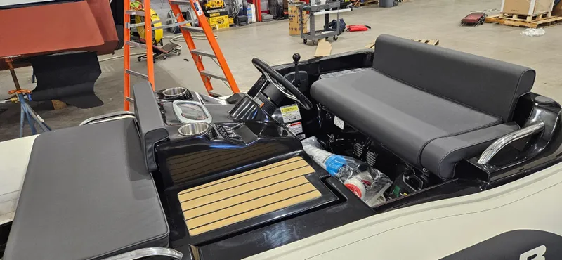 Slide: The Image of 2025 AB Inflatables 330 Jet Boat interior with seating and controls in a workshop setting. - 5