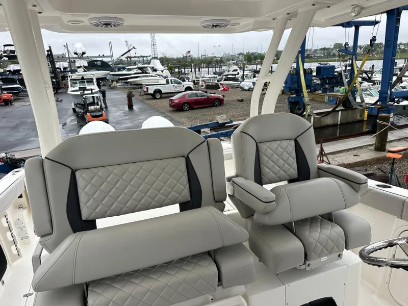 Slide: The Image of 2024 Pursuit S 328 Sport boat with luxurious seating at a marina. - 13