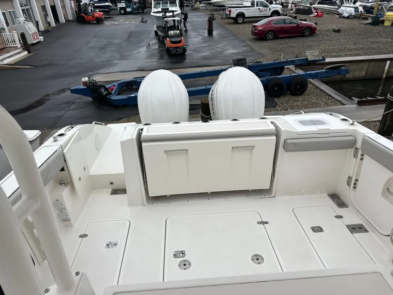 Slide: The Image of 2024 Pursuit S 328 Sport boat deck with storage compartments and dual engines. - 16