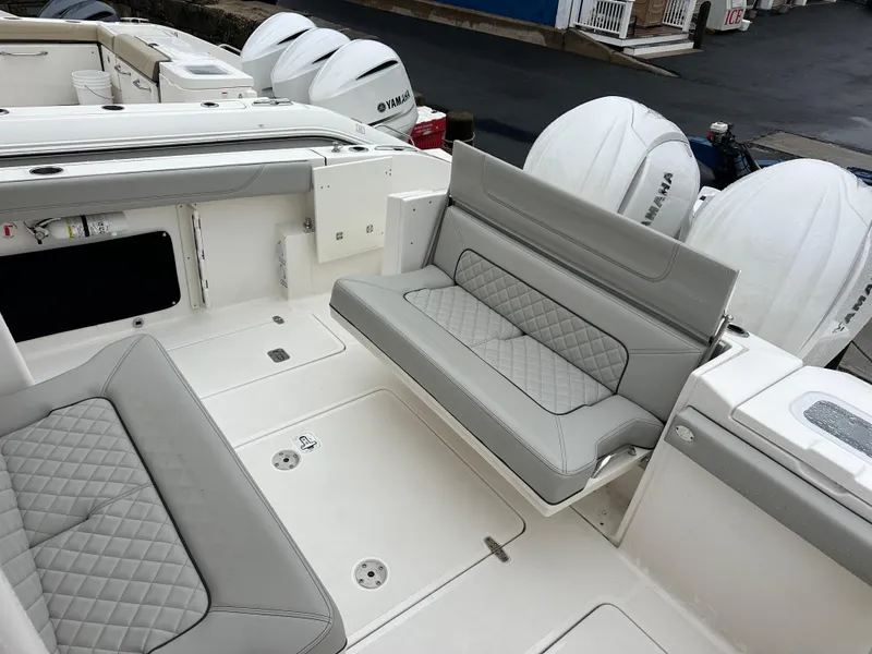 Slide: The Image of 2024 Pursuit S 328 Sport boat interior with cushioned seating and multiple outboard engines. - 20