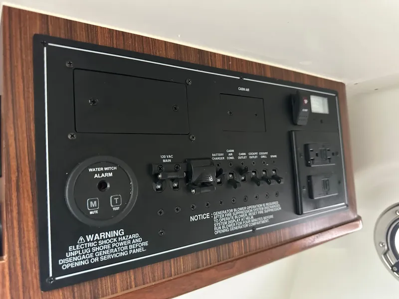 Slide: The Image of Control panel of 2024 Pursuit S 328 Sport boat with switches and warning labels. - 7