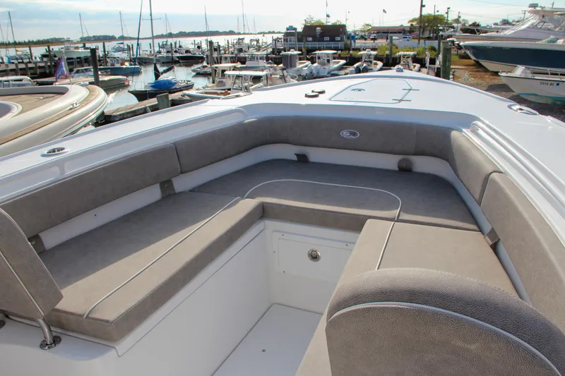 Slide: The Image of 2025 Sea Hunt Ultra 275 SE boat interior with cushioned seating at marina. - 19